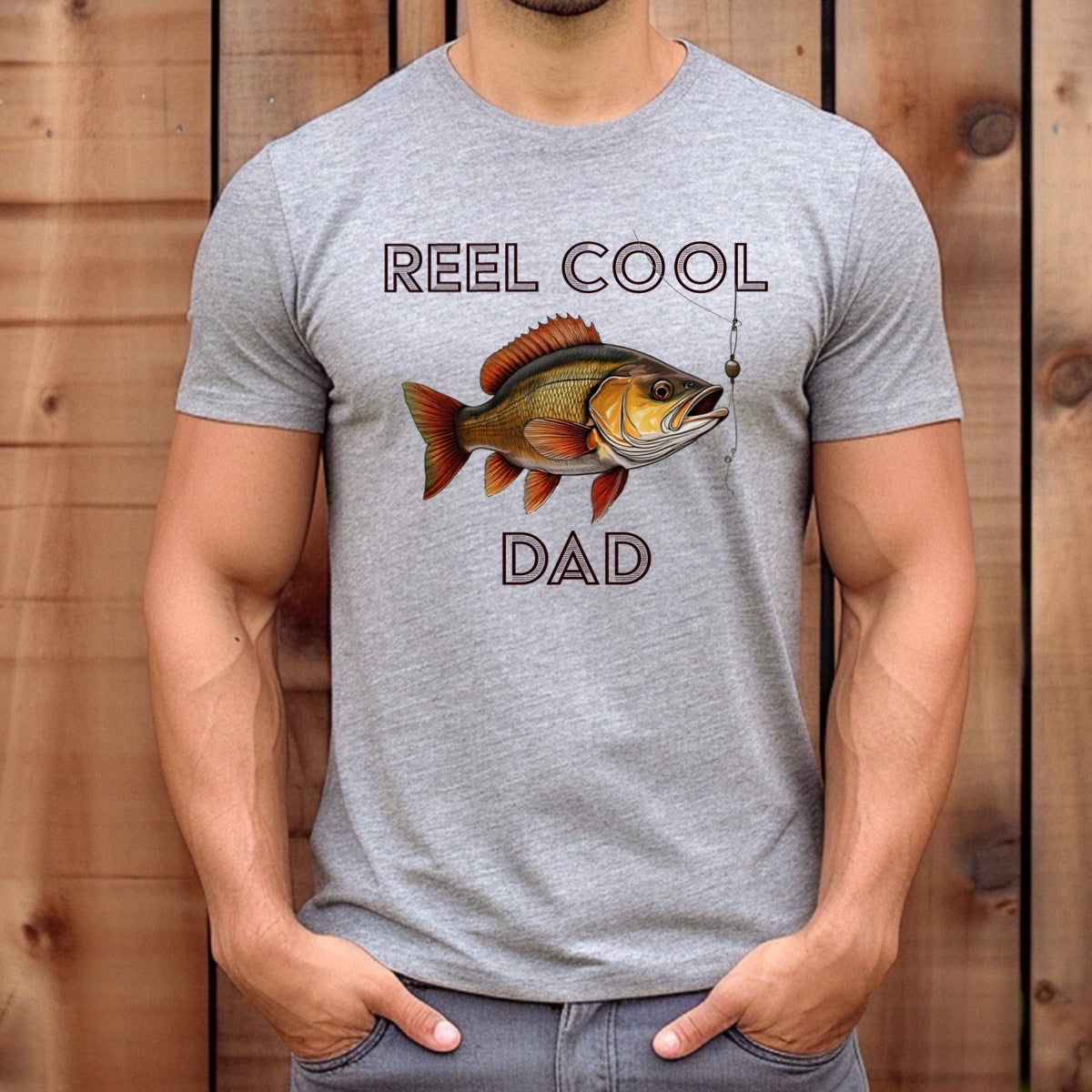 Man wearing gray Reel Cool Dad fishing shirt with fish and hook design