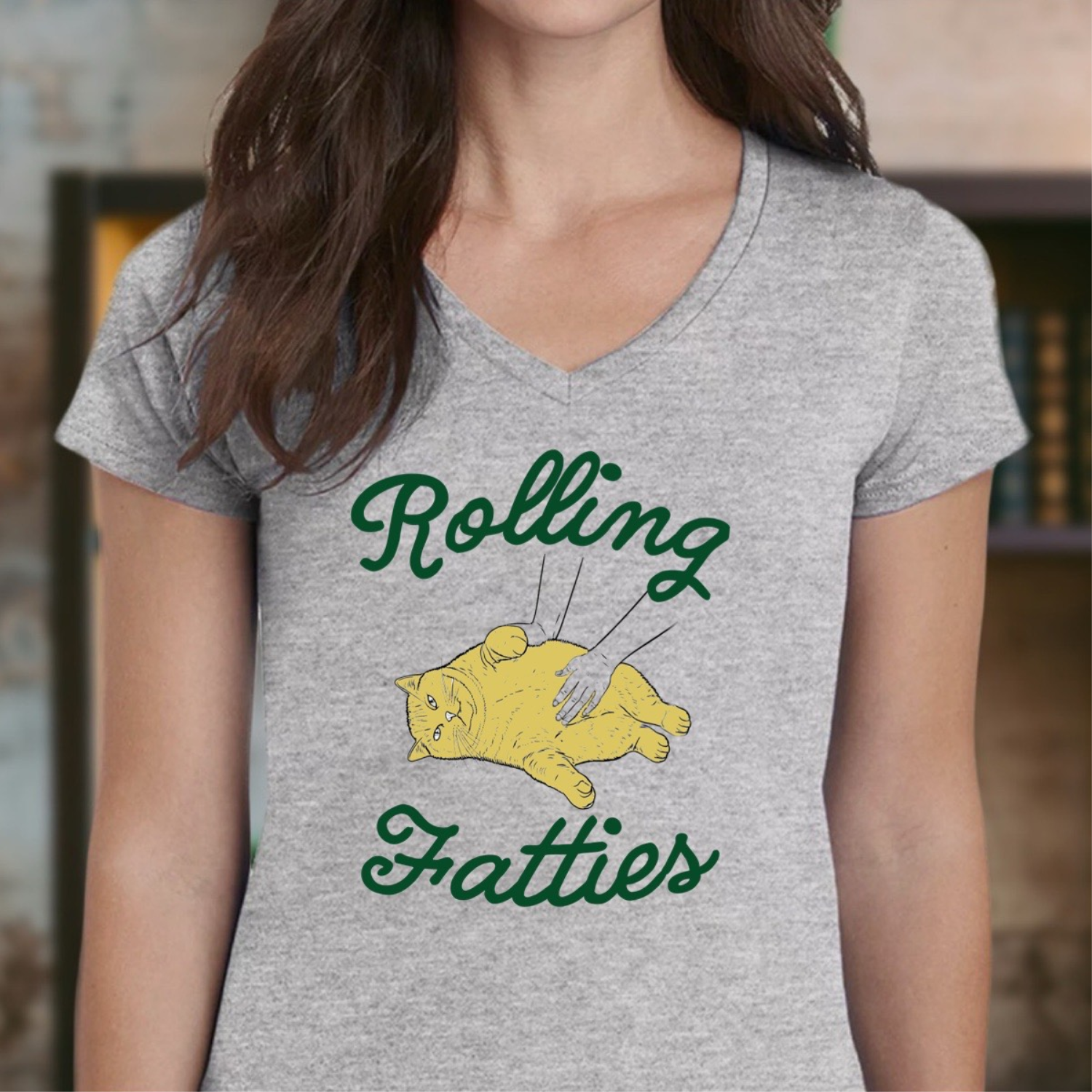 Woman wearing gray v-neck Rolling Fatties shirt with yellow cat belly rub graphic
