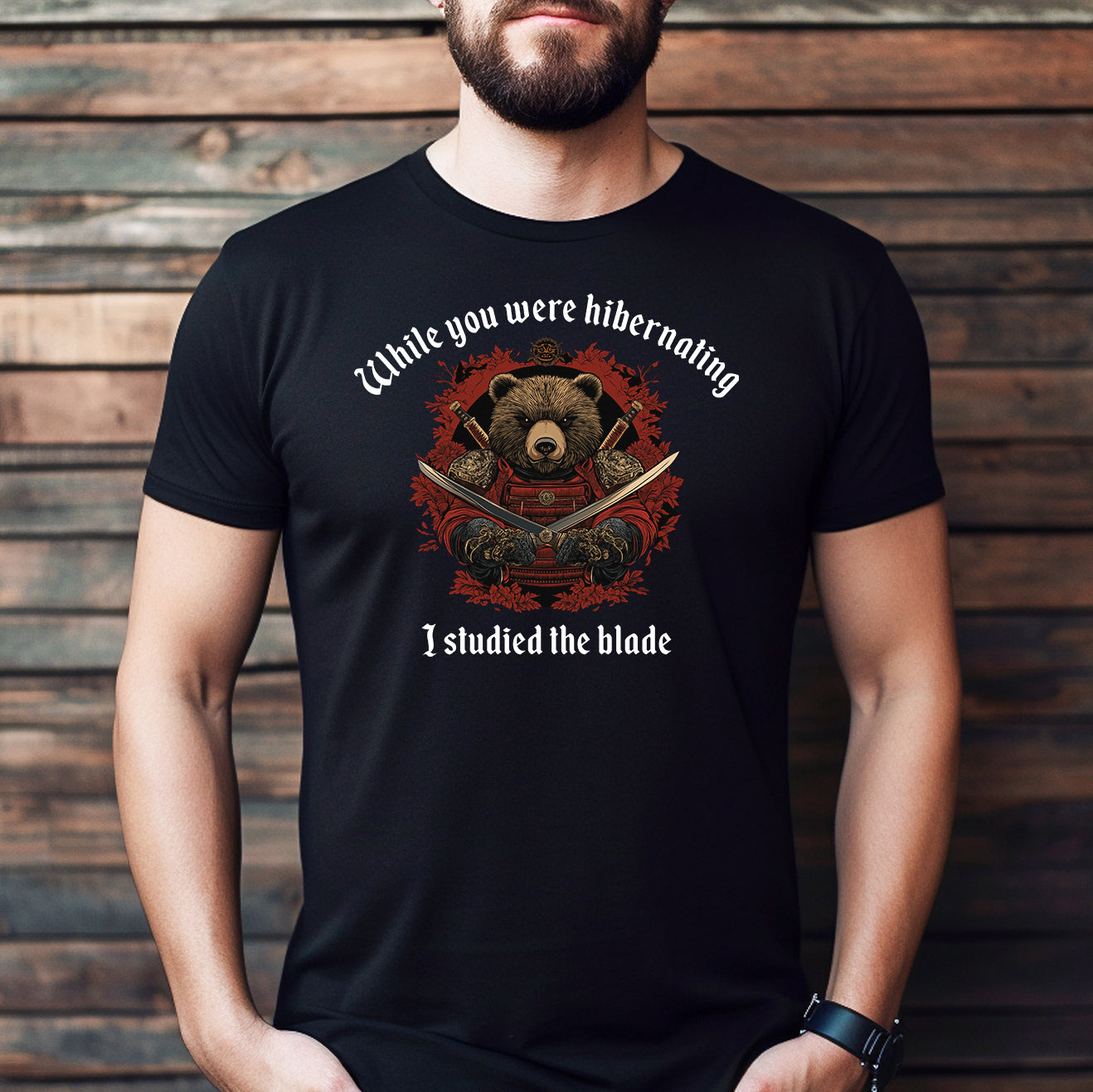Man wearing black graphic tee with samurai bear design and quote While you were hibernating I studied the blade