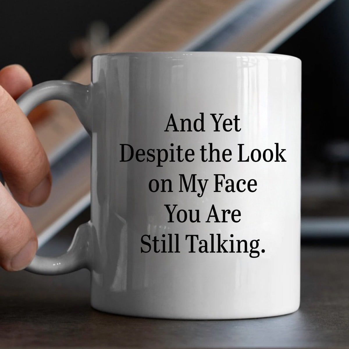 White ceramic mug in hands with sarcastic saying despite the look on my face you are still talking