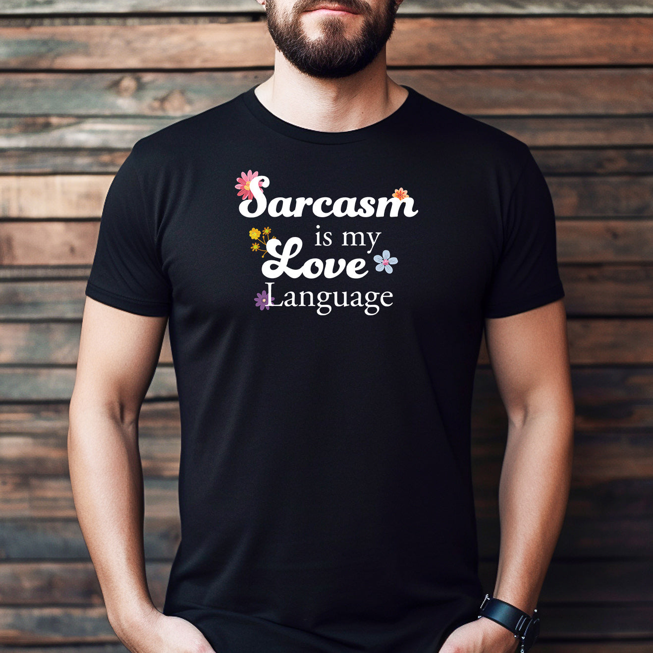 Man wearing a black T-shirt with colorful floral text that says “Sarcasm is my love language.”