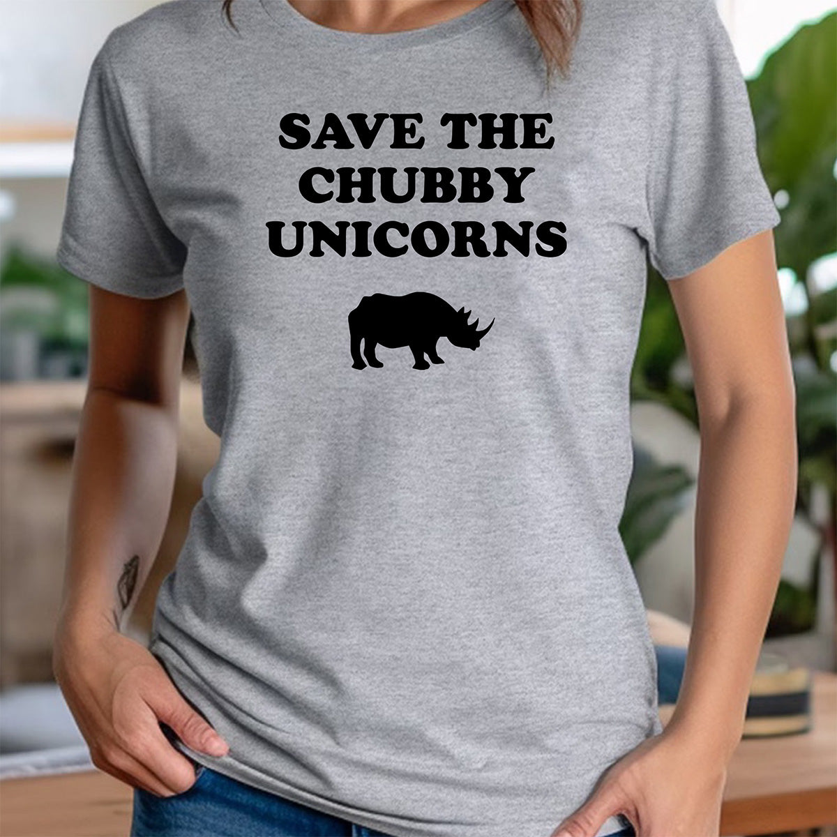 Woman in heather gray crewneck tee with Save the Chubby Unicorns text and rhino silhouette, humorous wildlife conservation shirt