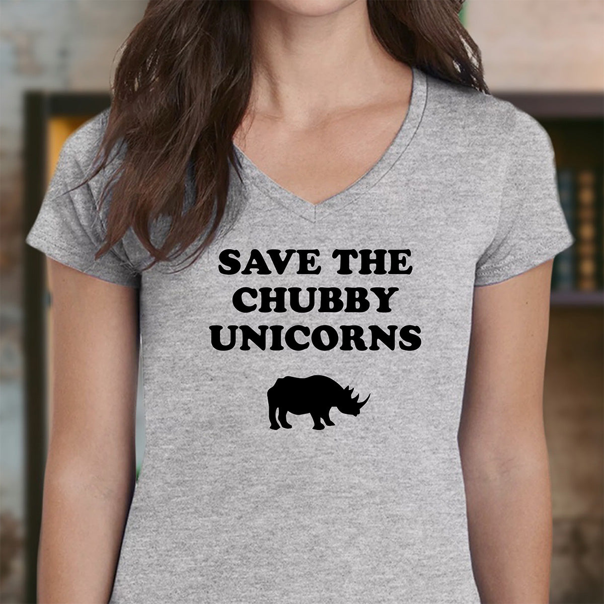 Woman in heather gray V-neck with Save the Chubby Unicorns wording and rhino graphic, funny animal conservation t-shirt