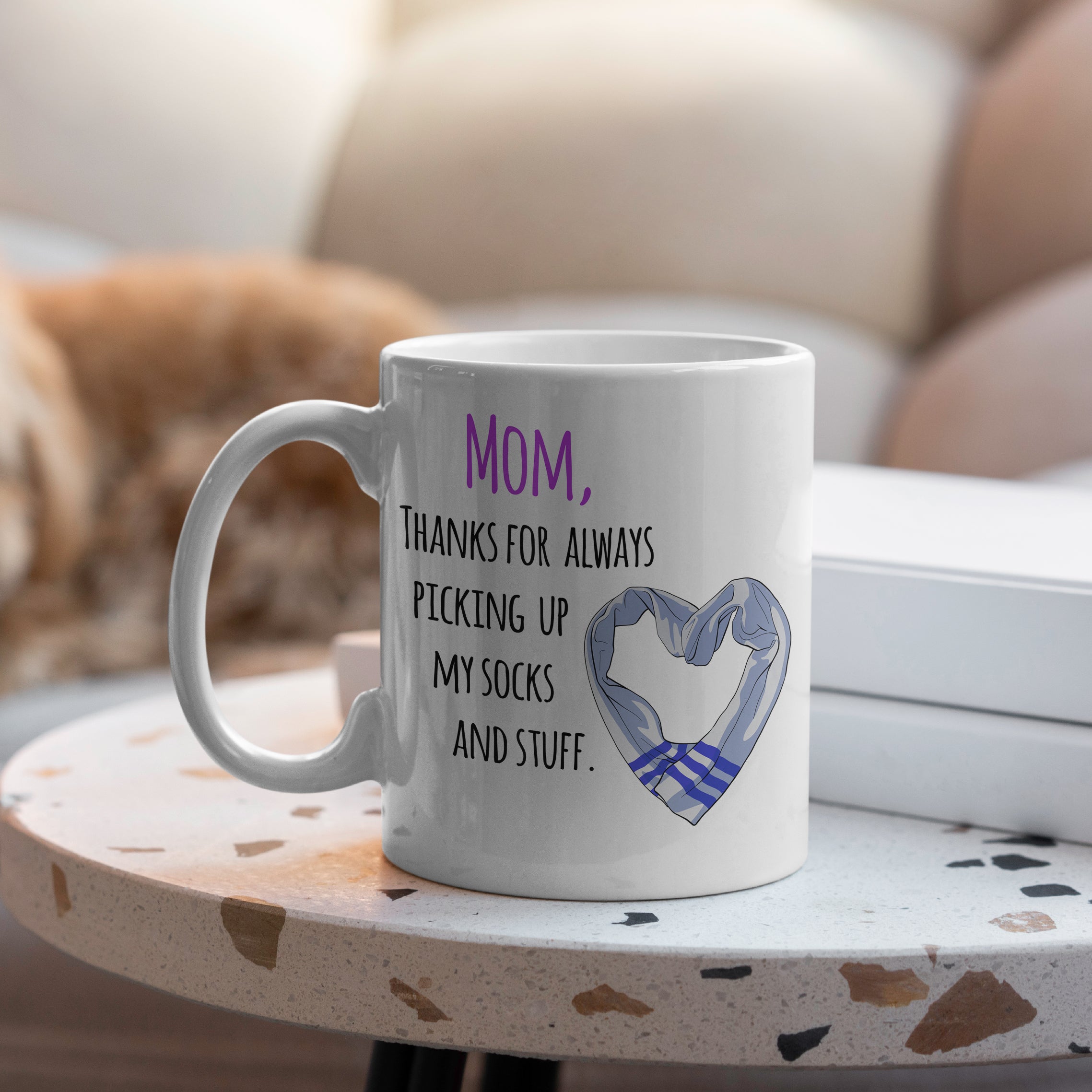 White mug on table with Mom thanks for always picking up my socks and stuff on table

