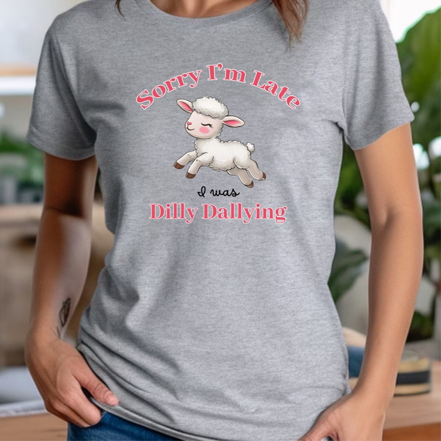 Woman in grey crewneck t-shirt featuring cute lamb and phrase Sorry I'm Late I was Dilly Dallying