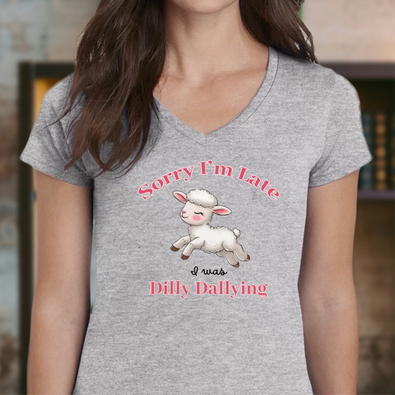 Woman wearing grey v-neck t-shirt with lamb illustration and text Sorry I'm Late I was Dilly Dallying