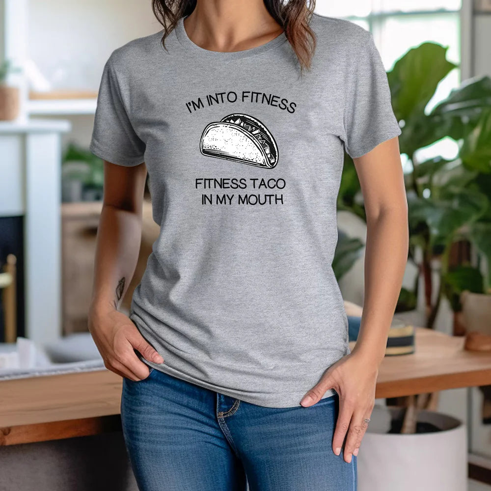 Woman in gray crew neck taco fitness t-shirt with humorous text and taco food graphic