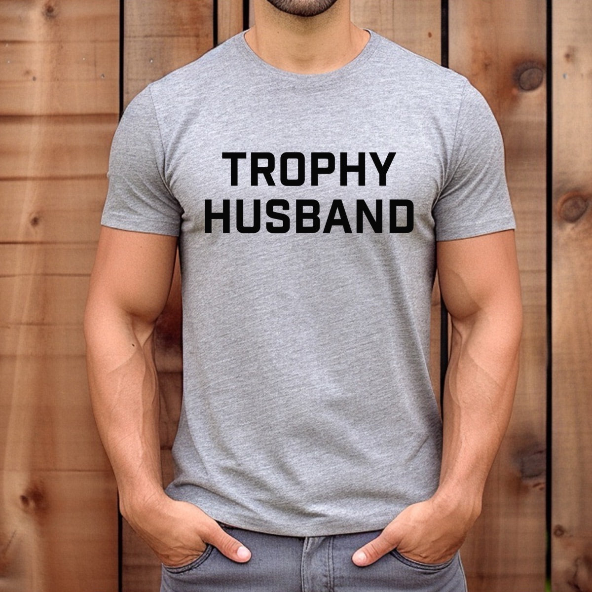 Man wearing gray Trophy Husband t-shirt with bold black text design