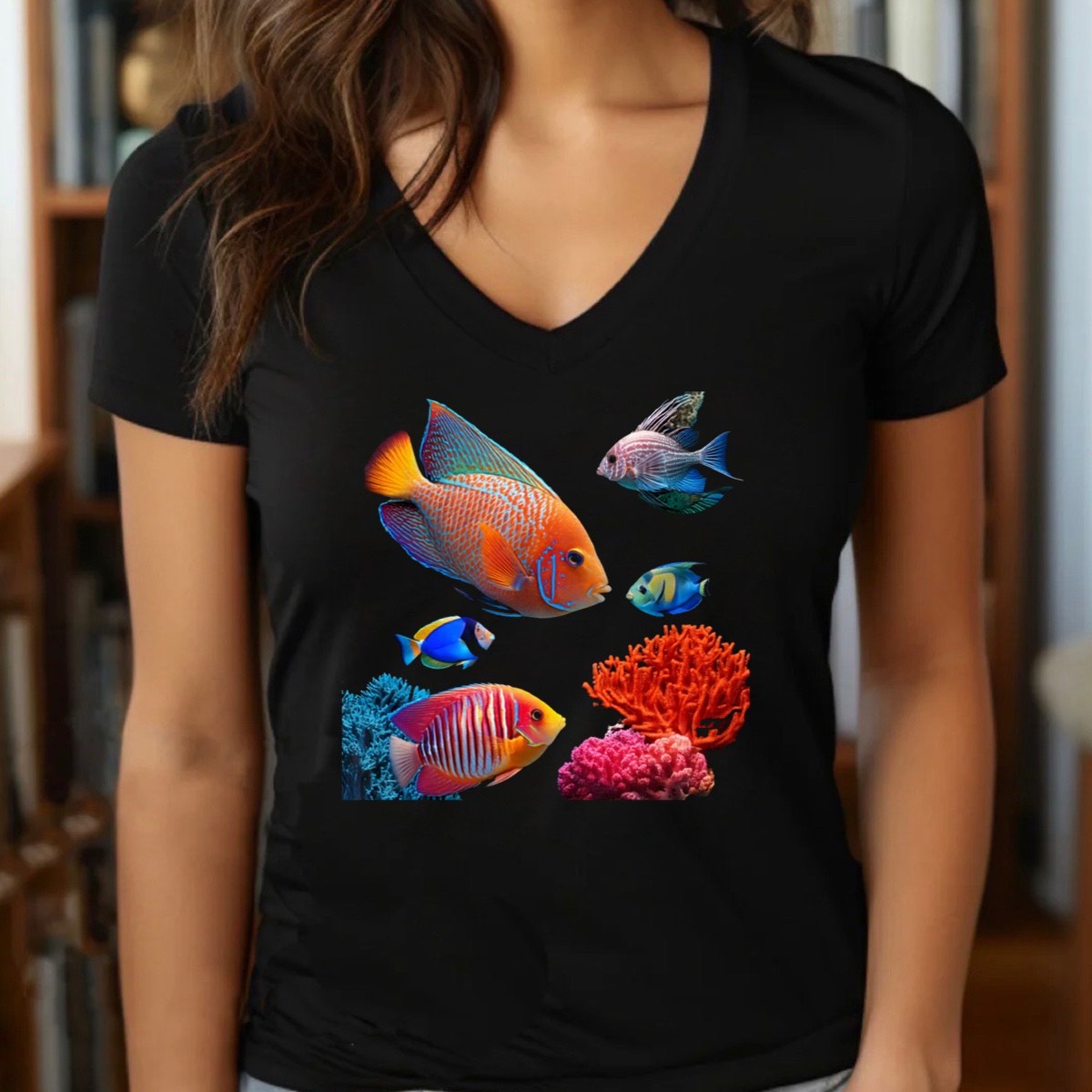 Woman wearing black v-neck t-shirt with colorful tropical reef fish and coral graphic, indoor lifestyle