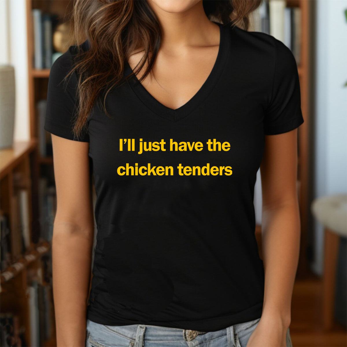 Woman in a black v-neck t-shirt with yellow print that says I’ll just have the chicken tenders