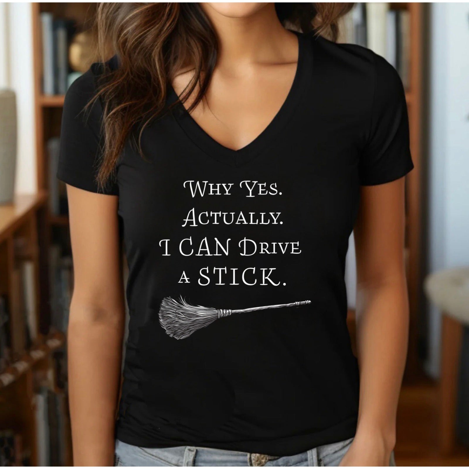 Black vneck crewneck t-shirt featuring broomstick illustration with Why Yes Actually I Can Drive a Stick