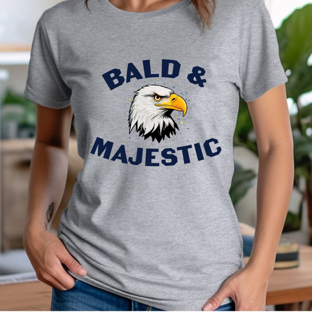 Woman in grey crewneck t-shirt with Bald & Majestic bald eagle head graphic