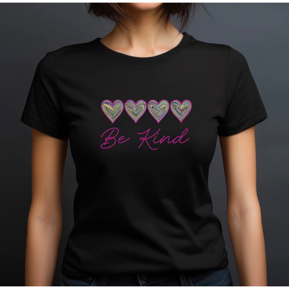 Woman in crewneck black Be Kind t-shirt with colorful hearts and pink script lettering