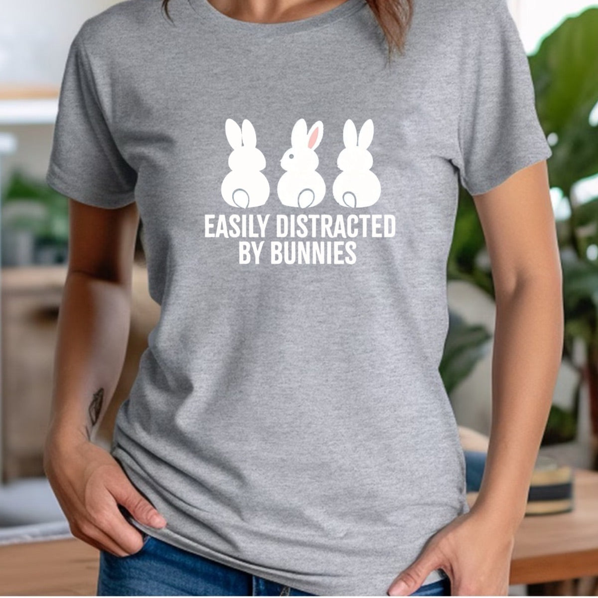 Woman in gray crew neck t-shirt featuring bunny design with text easily distracted by bunnies