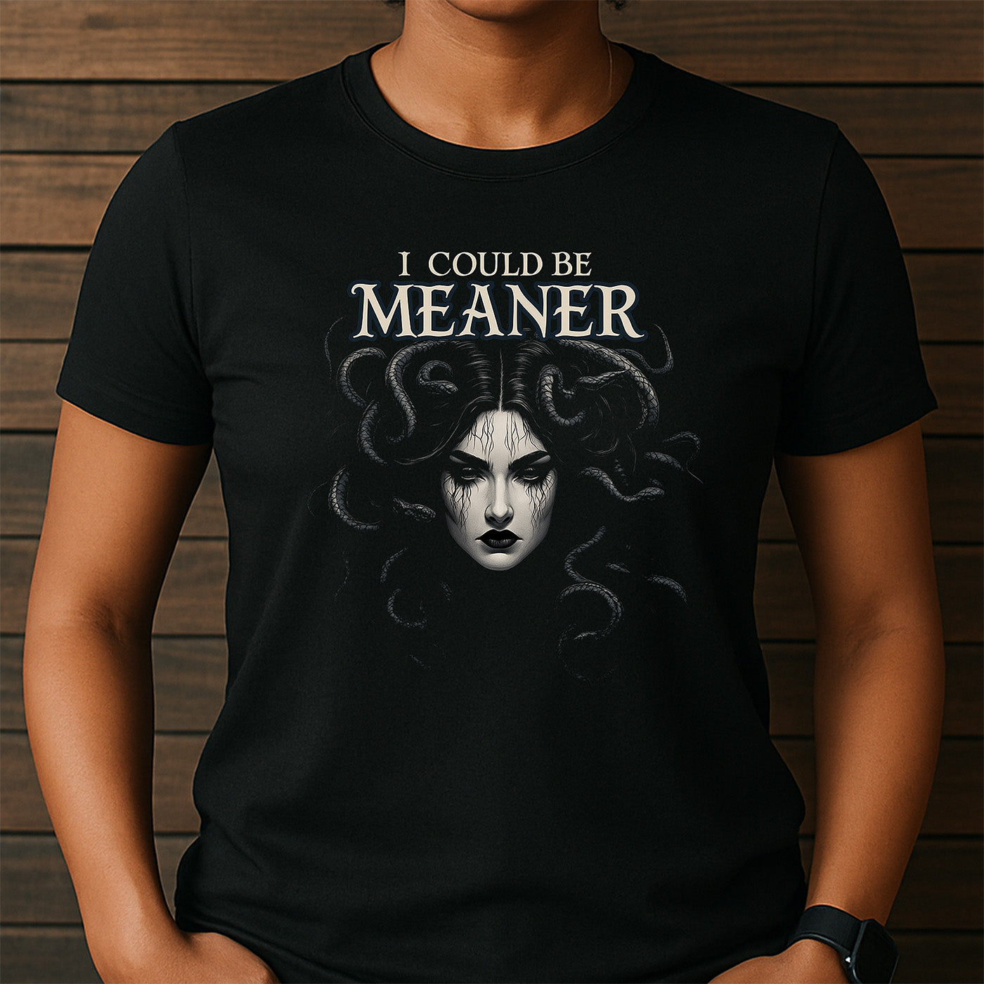 woman wearing crew neck black t-shirt featuring medusa face and phrase i could be meaner