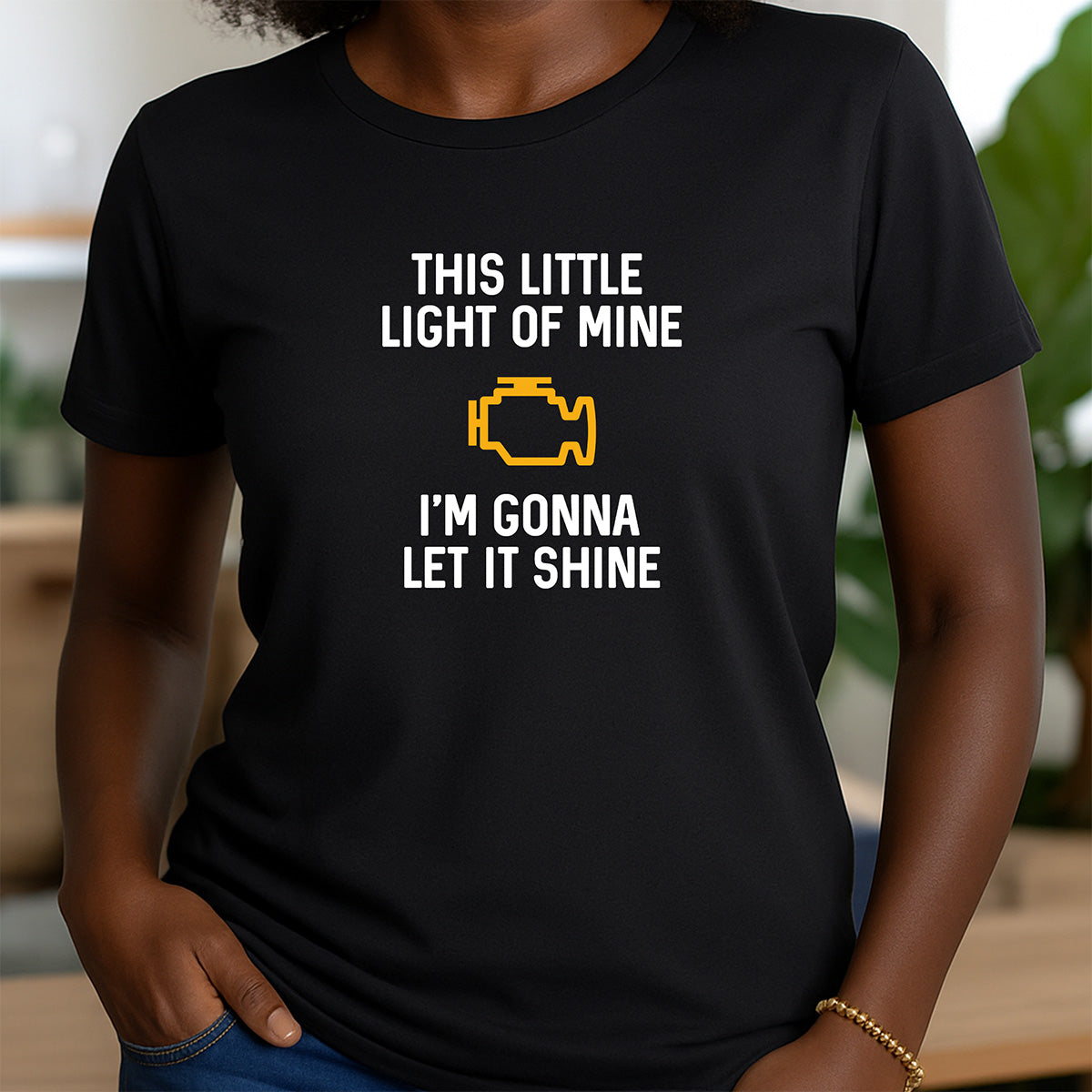 Woman in black crewneck t-shirt with humorous check engine light and text This Little Light of Mine I’m Gonna Let It Shine