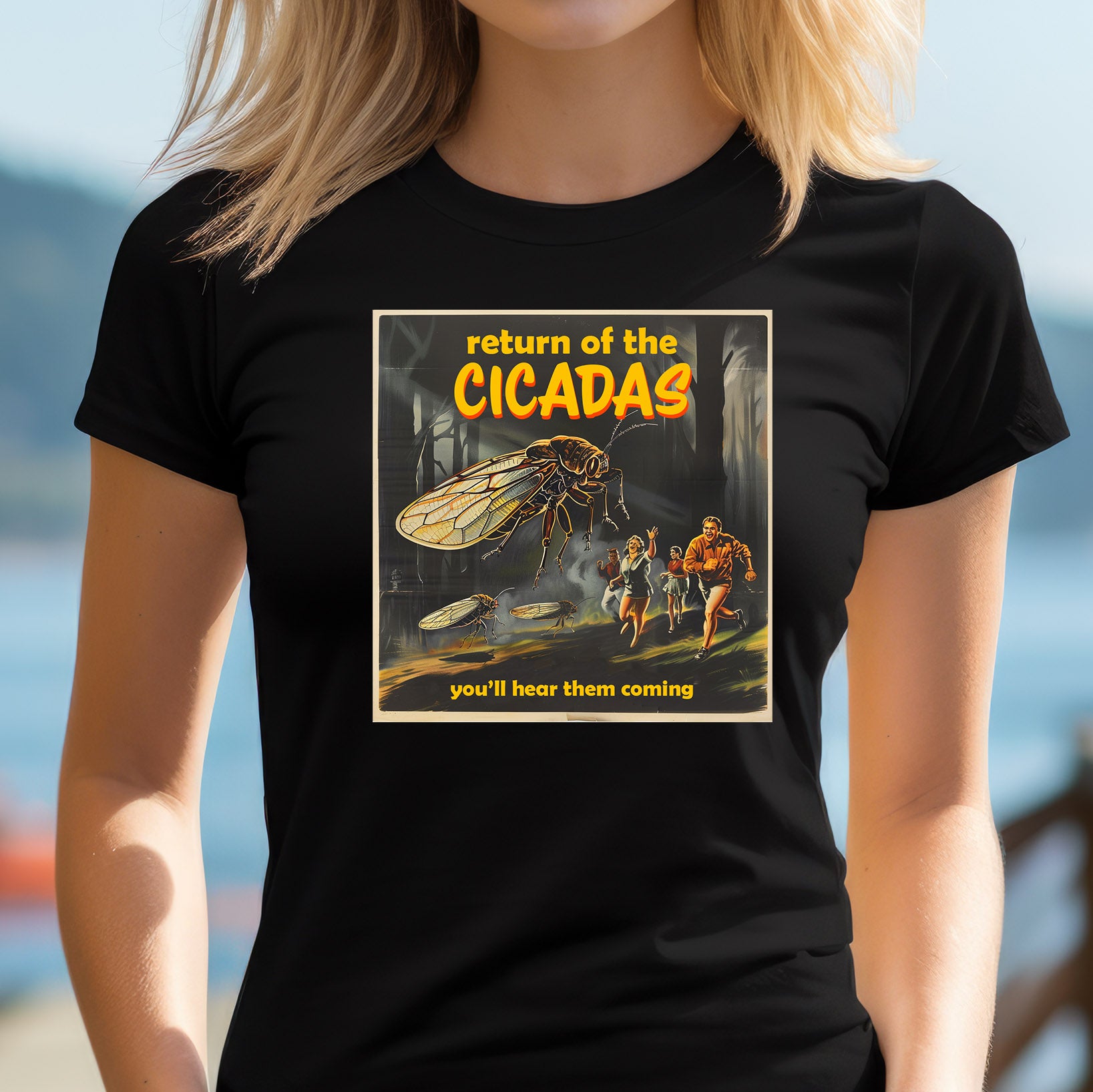 Woman wearing black T-shirt featuring giant cicada attack graphic with retro horror movie style.