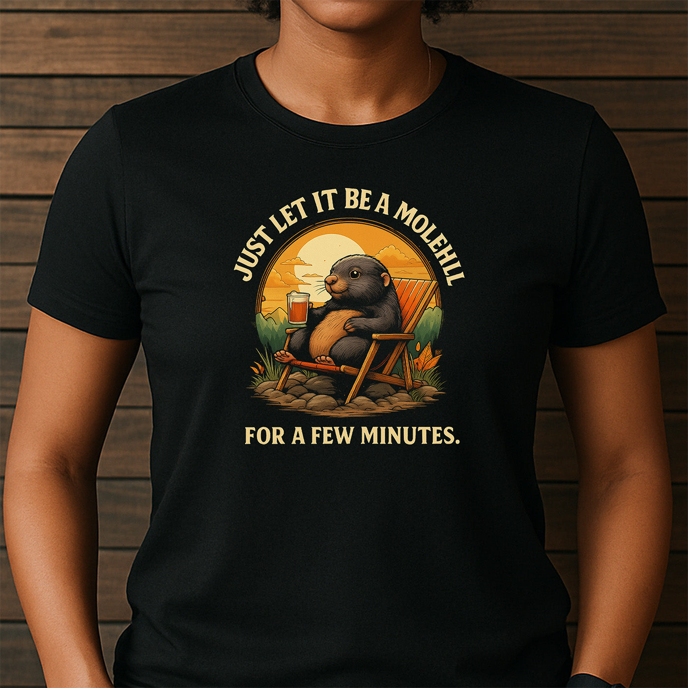 woman in crew neck black t-shirt with cartoon mole lounging and message just let it be a molehill for a few minutes