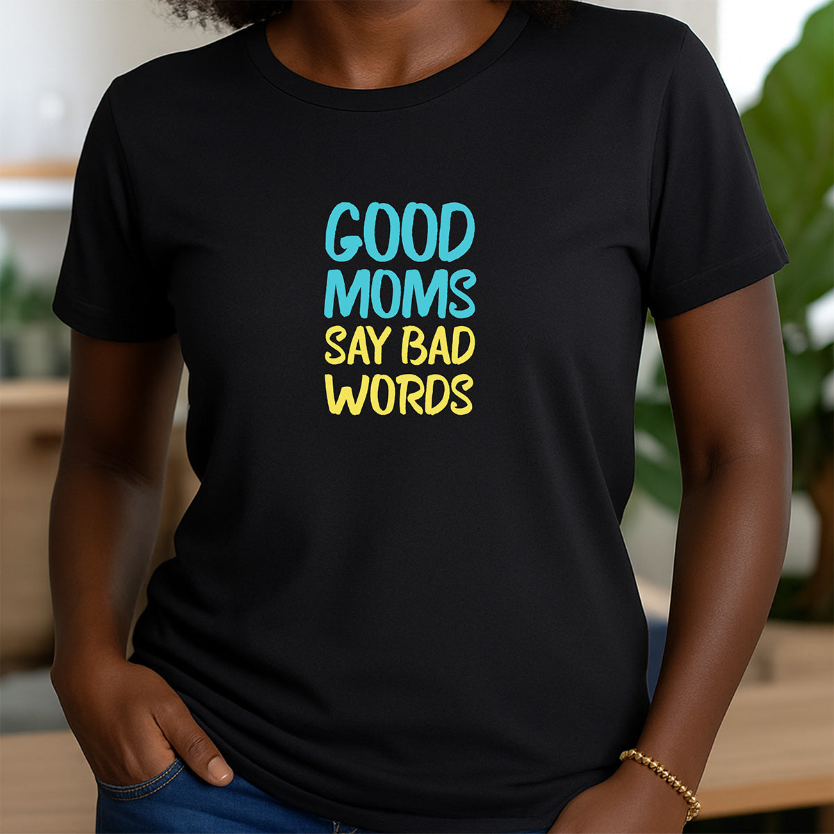 Woman in black crew neck graphic tee with colorful text Good Moms Say Bad Words in blue and yellow letters
