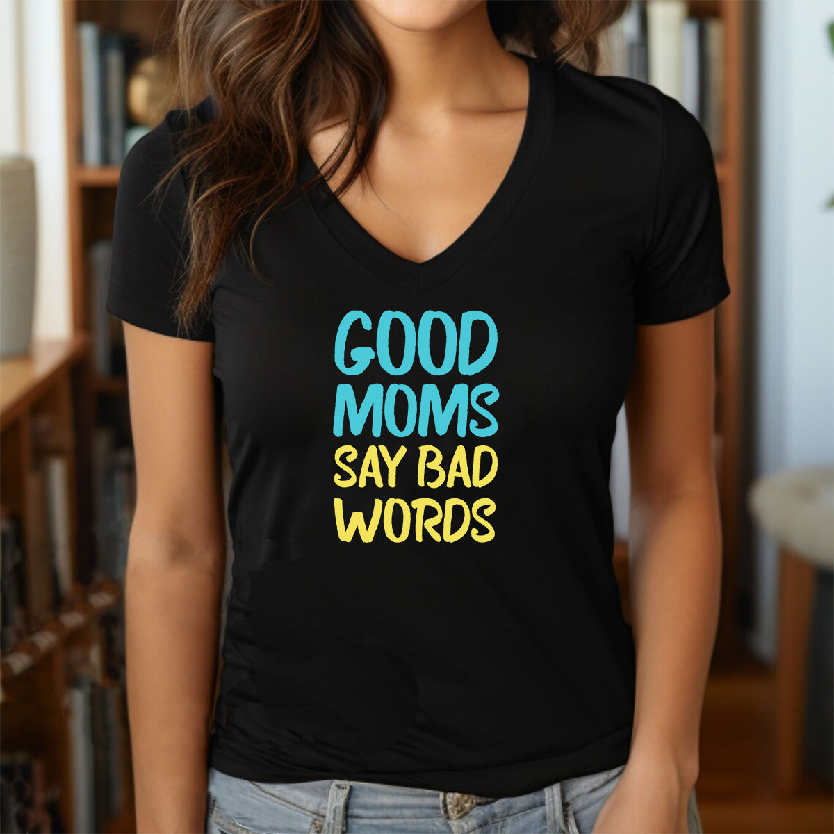 Woman in black  v-neck graphic tee with colorful text Good Moms Say Bad Words in blue and yellow letters