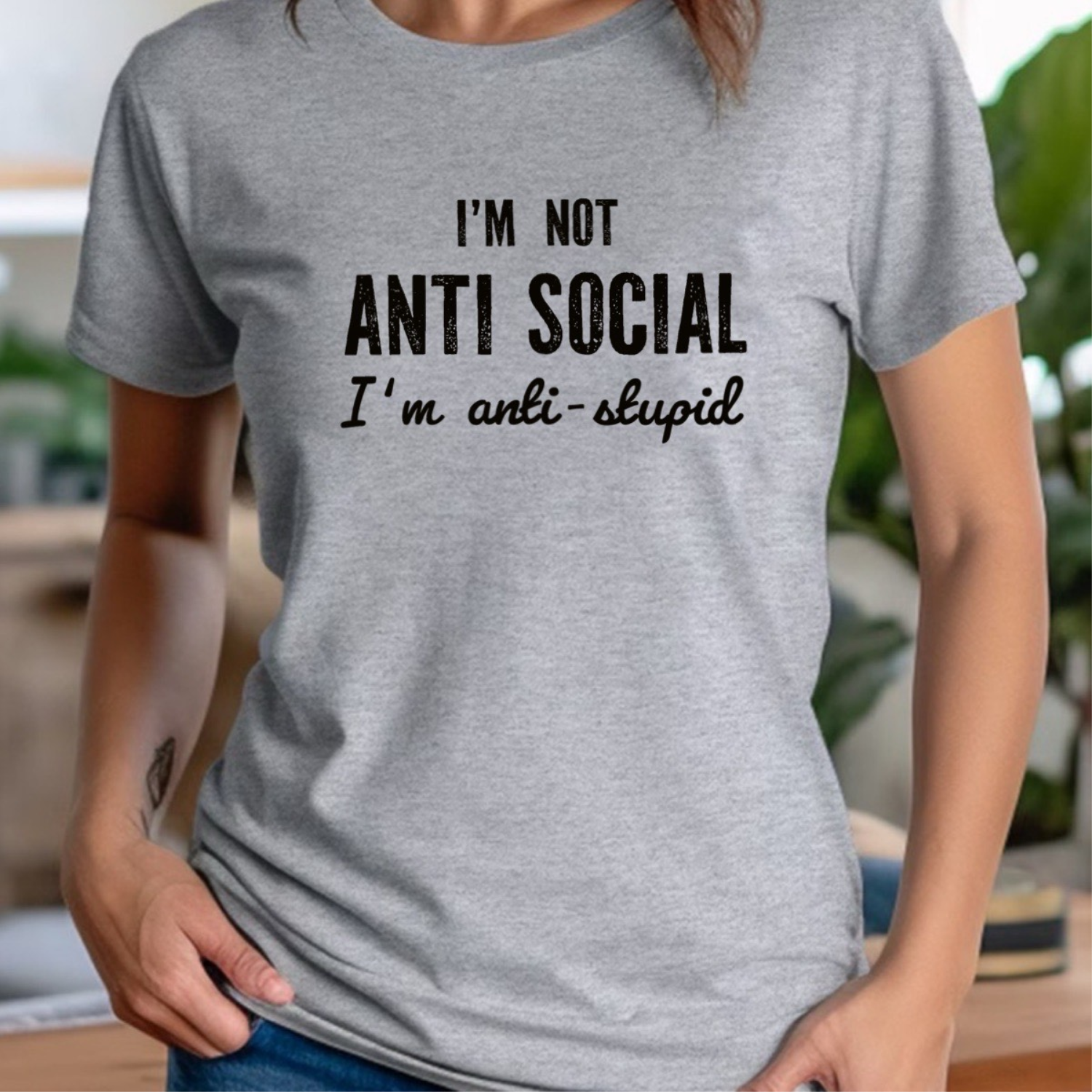 Woman in heather grey crew neck t-shirt featuring bold text I'm not anti social I'm anti stupid
