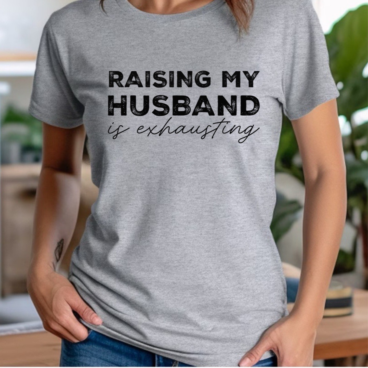 Woman in grey crew neck t-shirt with black text raising my husband is exhausting casual style