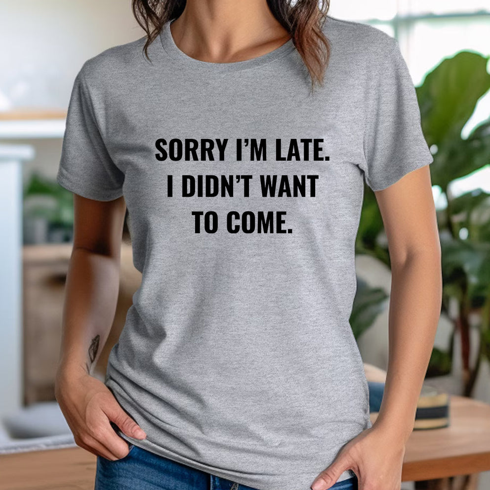 Woman in casual outfit wearing grey shirt with sarcastic slogan sorry I’m late I didn’t want to come