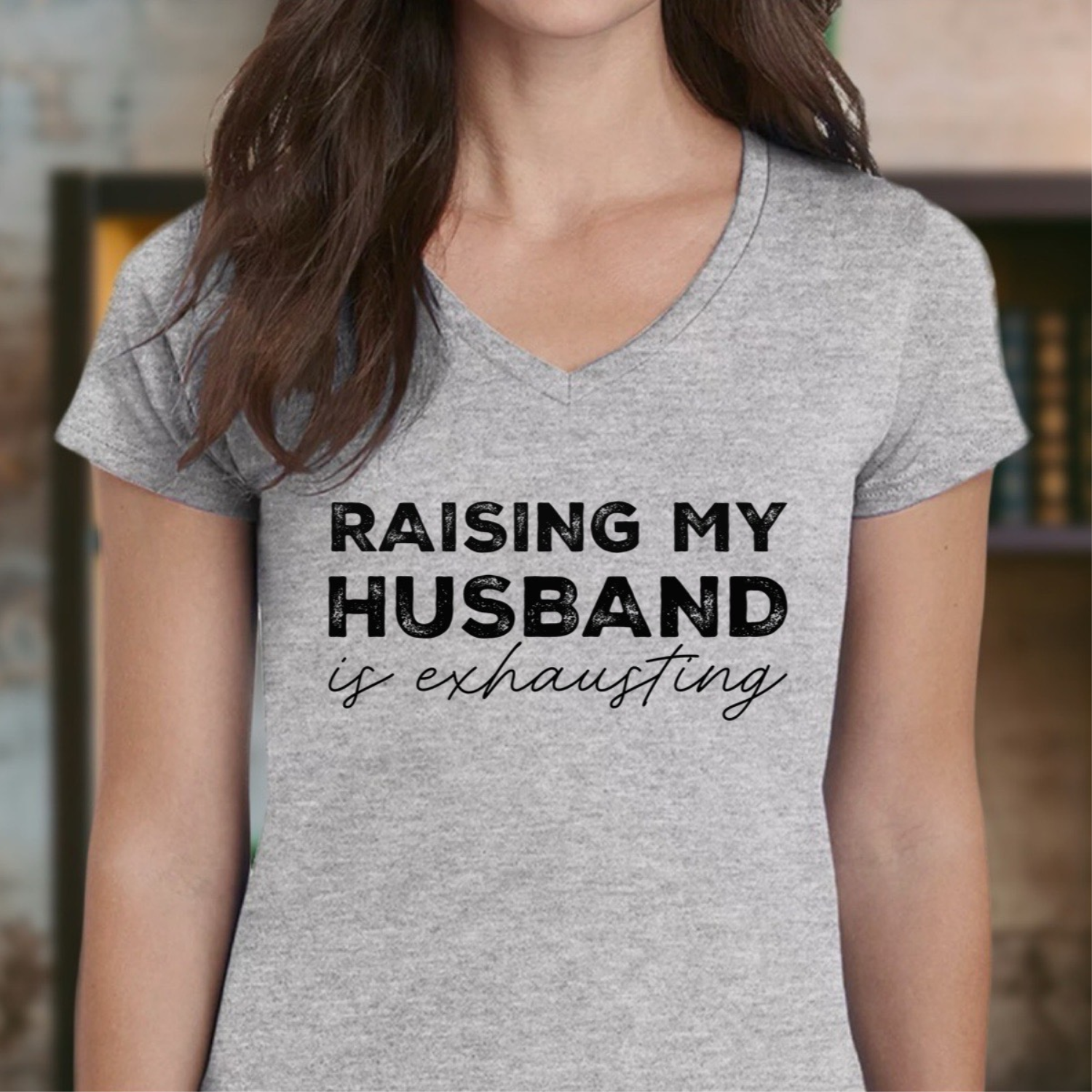 Woman in grey v-neck t-shirt with black text raising my husband is exhausting casual wear