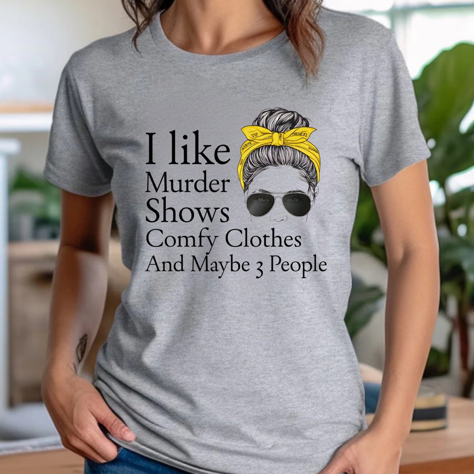 Women’s heather gray crewneck tee with Murder Shows Comfy Clothes And Maybe 3 People quote, indoor mockup