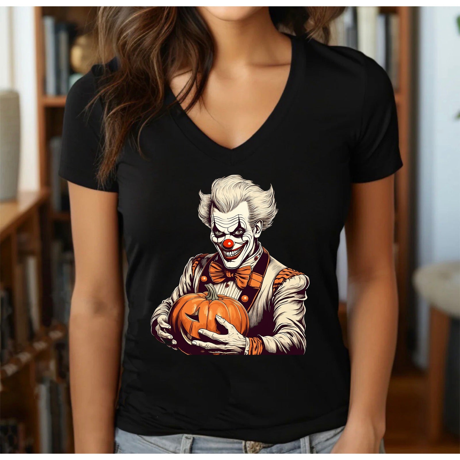 Women’s black v-neck Halloween t-shirt with creepy clown holding pumpkin in cozy room