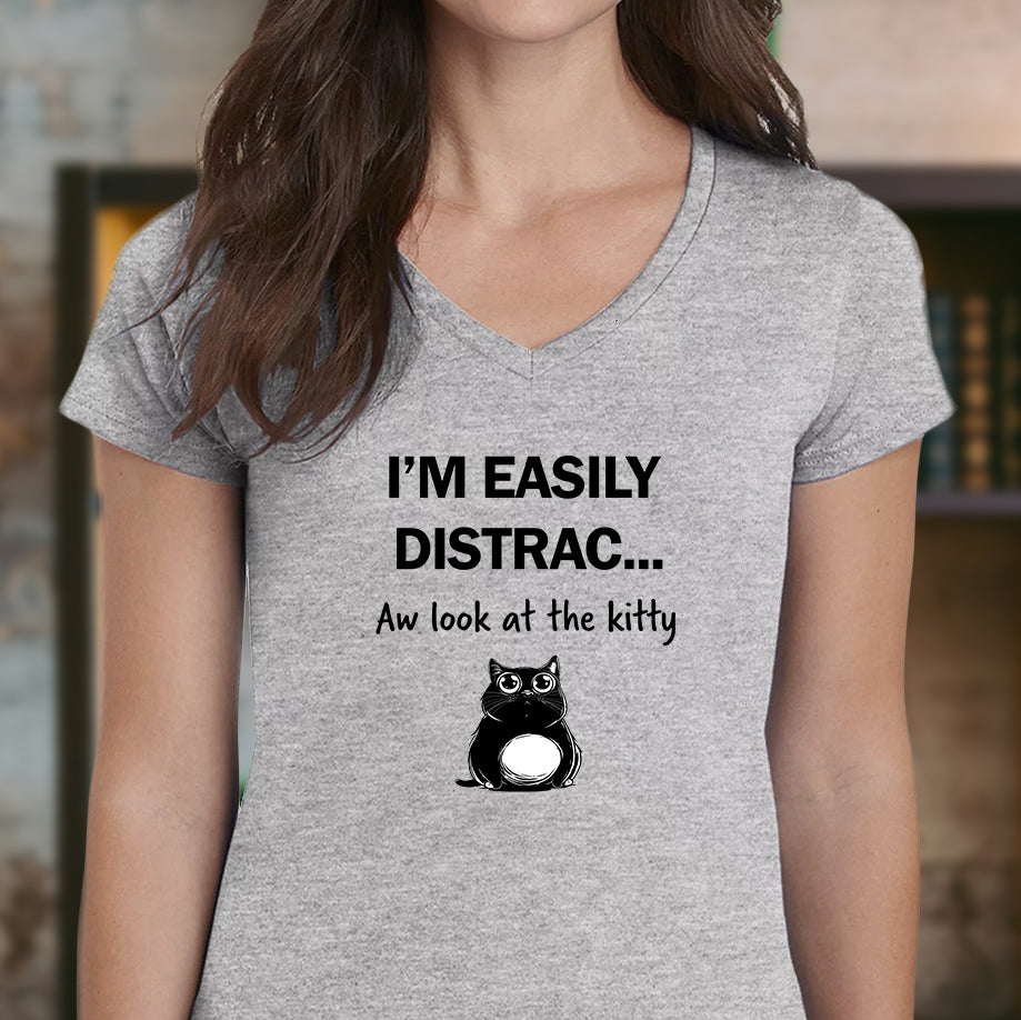 Woman wearing gray v-neck t-shirt with funny cat illustration and easily distracted kitty text