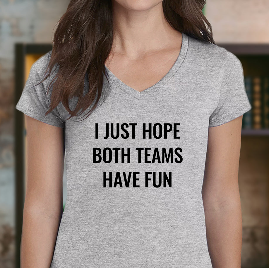 Woman wearing gray v-neck t-shirt with bold text saying "I Just Hope Both Teams Have Fun."