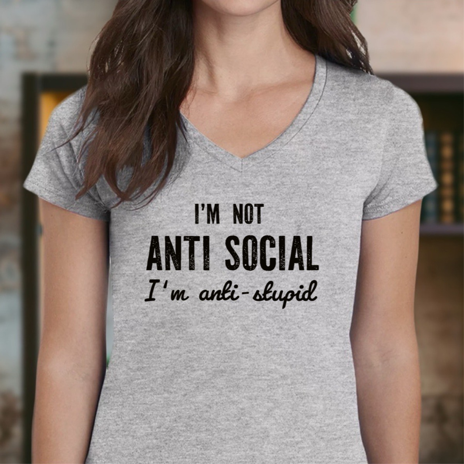 Woman in grey v-neck t-shirt with humorous black text saying I'm not anti social I'm anti stupid