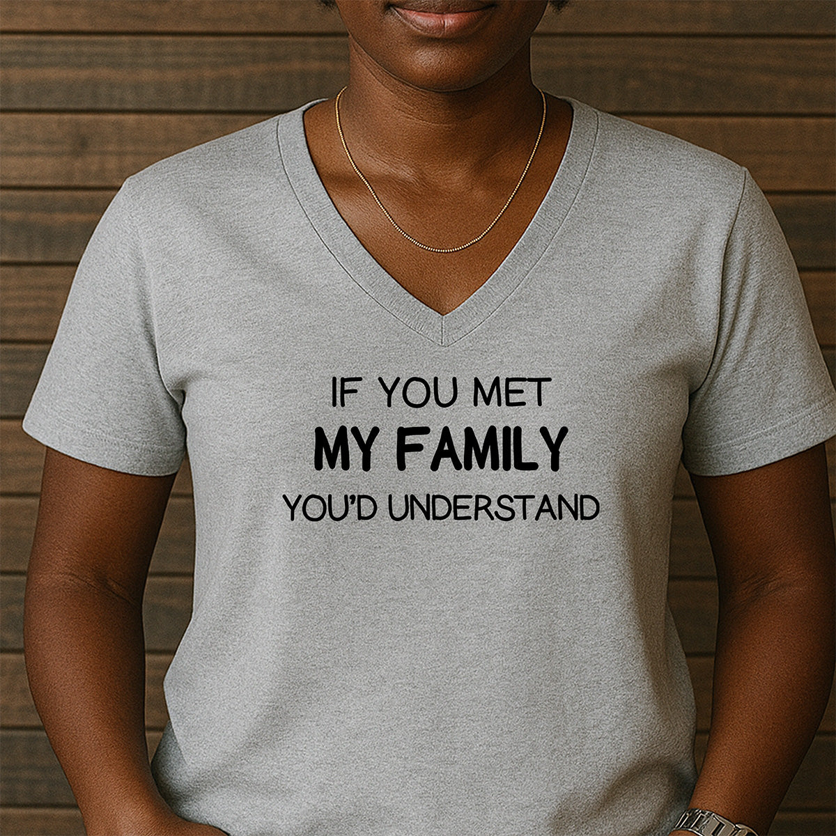 Woman in grey v-neck t-shirt with black text If You Met My Family You’d Understand