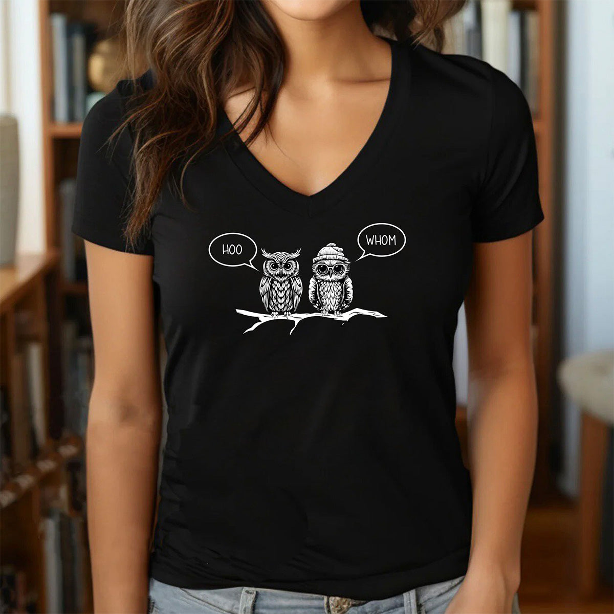 Woman in black v-neck t-shirt featuring two owls with speech bubbles hoo and whom, playful grammar pun shirt