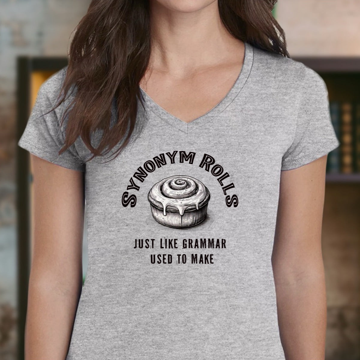 Woman wearing v-neck grey synonym rolls grammar pun t-shirt with cinnamon roll print