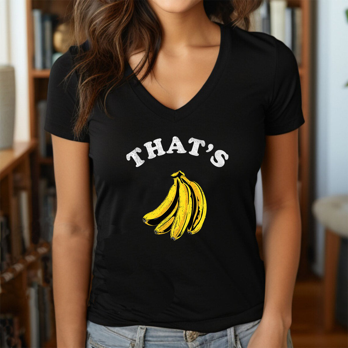 Woman wearing black v-neck "That's Bananas" t-shirt with yellow banana illustration and white text.